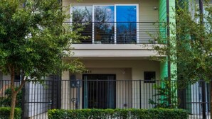 A modern apartment building with a flat roof, large windows, and a balcony. - Midtown with a View! (Houston)