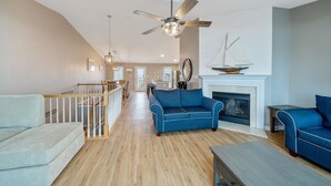 A spacious living room with a blue sofa, a wooden coffee table, and a fireplace.
