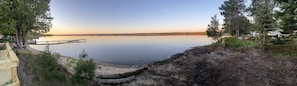 A lakeside view with a dock, a small building, and a forested area. - Lakefront Cabin... Ride To All The Snowmobile Trails From The Cabin (Newberry)