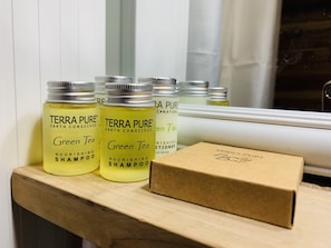 A shelf with several bottles of Terra Pure Green Tea Nourishing Shampoo and a Terra Pure box. - Lakefront Cabin... Ride To All The Snowmobile Trails From The Cabin (Newberry)