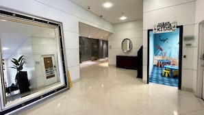 A hotel lobby with a large mirror, a reception desk, and an 'Ocean Reserve Kids' play area.