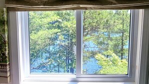 A room with a window overlooking a forested area.