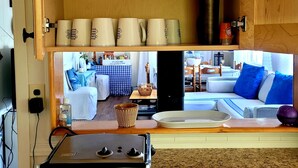 A kitchen with a granite countertop, a stove, and a cabinet with various kitchen items.