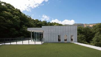 A modern building with a flat roof, large glass windows, and a concrete exterior.