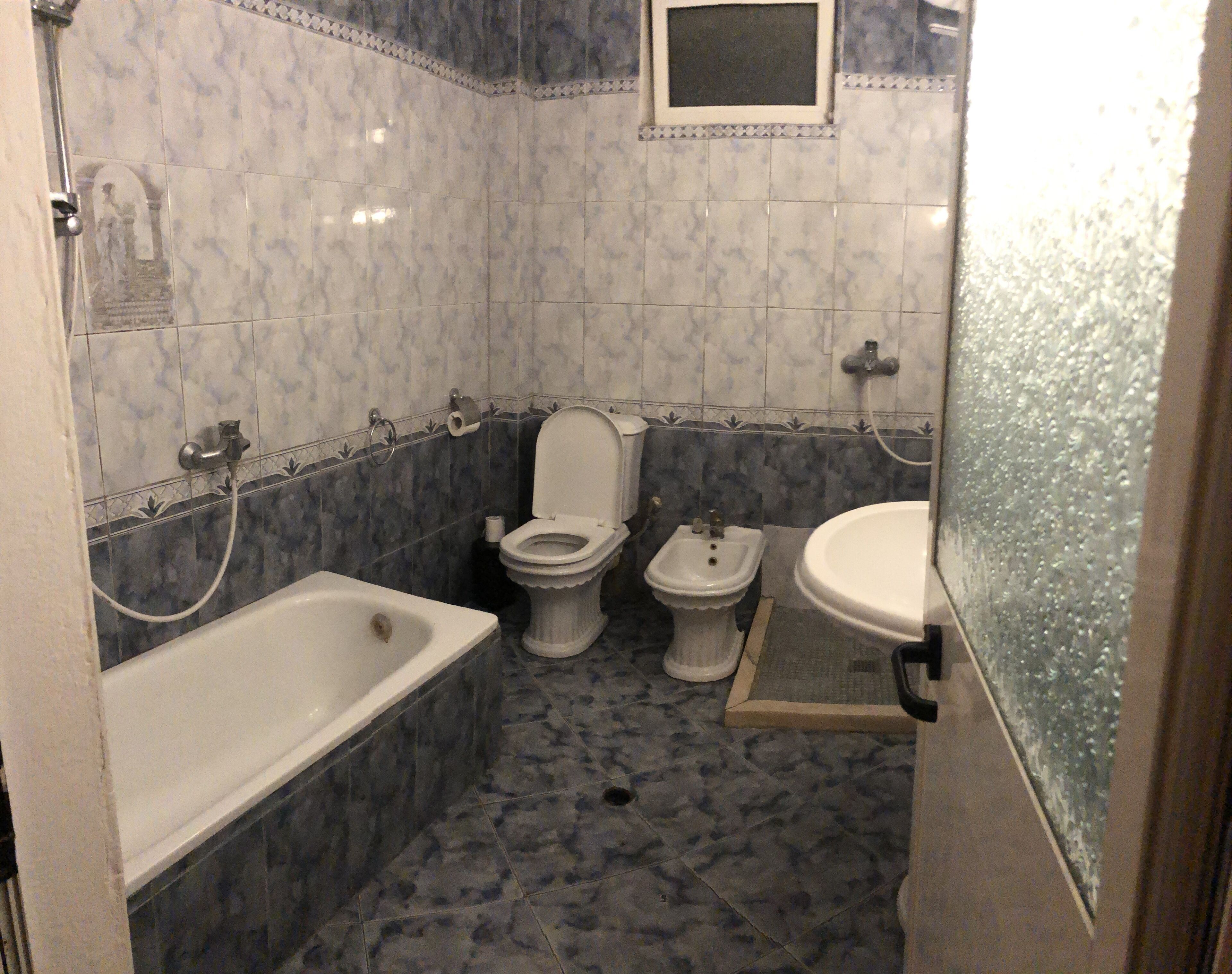 A bathroom with a bathtub, a toilet, and a bidet.