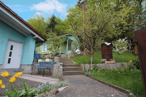 A residential property with a front yard, a staircase leading to a house, and a wooden bench.