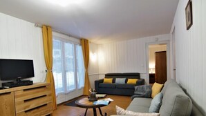 En stue med fjernsyn, sofa og sofabord.