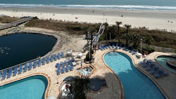 Een resort met een zwembad, een strand en uitzicht op de oceaan.