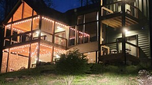 A modern two-story house with a large deck and string lights. - Firefly Haus - Hot Tub, Firepit, 10min to Smokies (Gatlinburg)