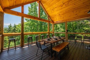 Enjoy dining al fresco on the spacious deck with a view of the surrounding forest.
