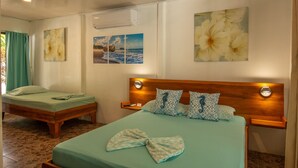 Quarto de hotel com duas camas, uma cabeceira de madeira e obras de arte na parede.