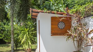 Um pequeno edifício branco com porta de madeira e um alvo de dardos na parede.
