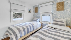 A bedroom with two single beds, a window, and a wall with a wave pattern design. - The Daydreamer - Walk To Walnut Beach, Restaurant + Shops (Milford)