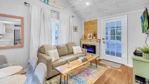 A cozy living room with a sofa, a coffee table, and a fireplace. - The Daydreamer - Walk To Walnut Beach, Restaurant + Shops (Milford)