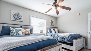 A bedroom with two beds, a ceiling fan, and artwork on the walls. - 2 minutes to the beach (Pensacola Beach)