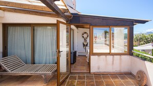 A balcony with a wooden bench, a door leading to an interior space, and a view of a beach and mountains. - 'Villa Casa Colina'with Pool and Wi-Fi (Albir)