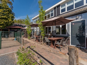 Relax in the serene outdoor patio area with comfortable seating and lush greenery.