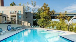 A swimming pool with lounge chairs and a building with a sign. - Rockin on the River!!! (Nashville)