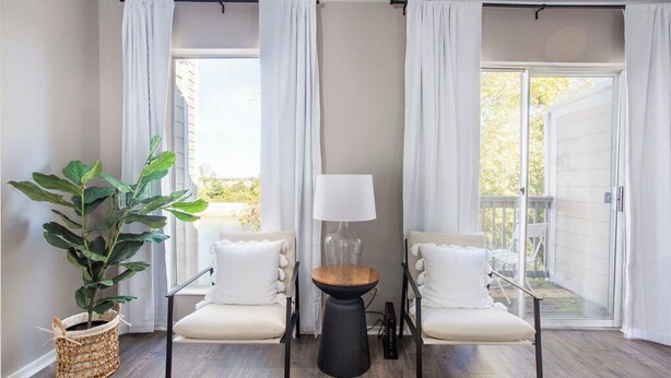 A room with two white chairs, a small table, and a potted plant. - Rockin on the River!!! (Nashville)