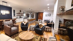 A spacious living area with a dining table, sofas, and a kitchen in the background. - Luxurious, downtown loft with a warm, family feel (Sheridan)