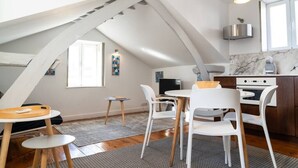 Een modern loft appartement met keuken, eethoek en een groot raam.