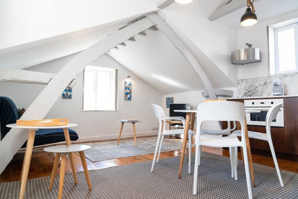 A modern loft apartment with a kitchen, dining area, and a cozy seating space.