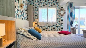 Een slaapkamer met een bed met een decoratieve spreidek, een hoofdbord, een nachtkastje en een raam met gordijnen.