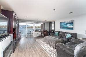 Enjoy a serene view of the lake and mountains from the comfort of this stylish living room.