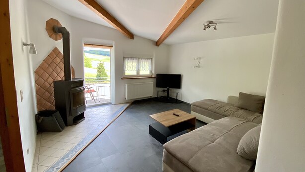 Una sala de estar con un sofá, una mesa de centro, un televisor y una chimenea.