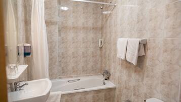 Un baño con bañera, lavamanos e inodoro.