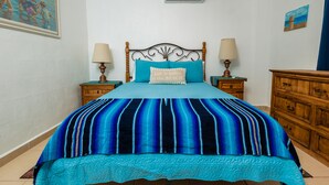Ein Schlafzimmer mit einem Bett, zwei Nachttischen, einer Holzkommode und einem Bild an der Wand.