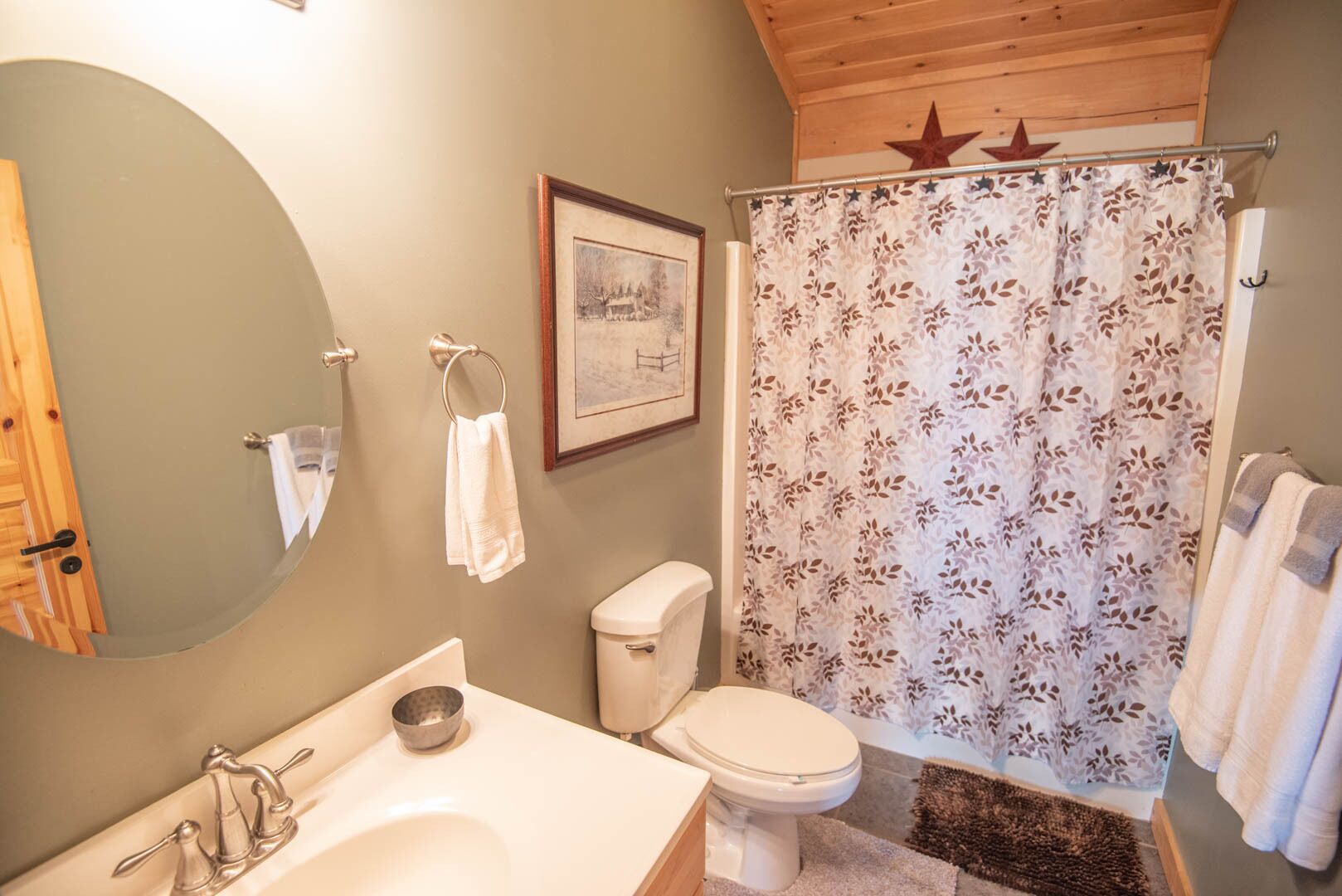 A bathroom with a bathtub, toilet, sink, and a framed picture on the wall.