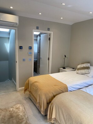 Quarto moderno com uma cama grande, uma mesa de cabeceira, um abajur e um guarda-roupa.
