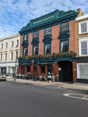 A building with the sign 'WALMER CASTLE' on the facade, featuring a traditional brick and green facade with multiple windows and a covered entrance.