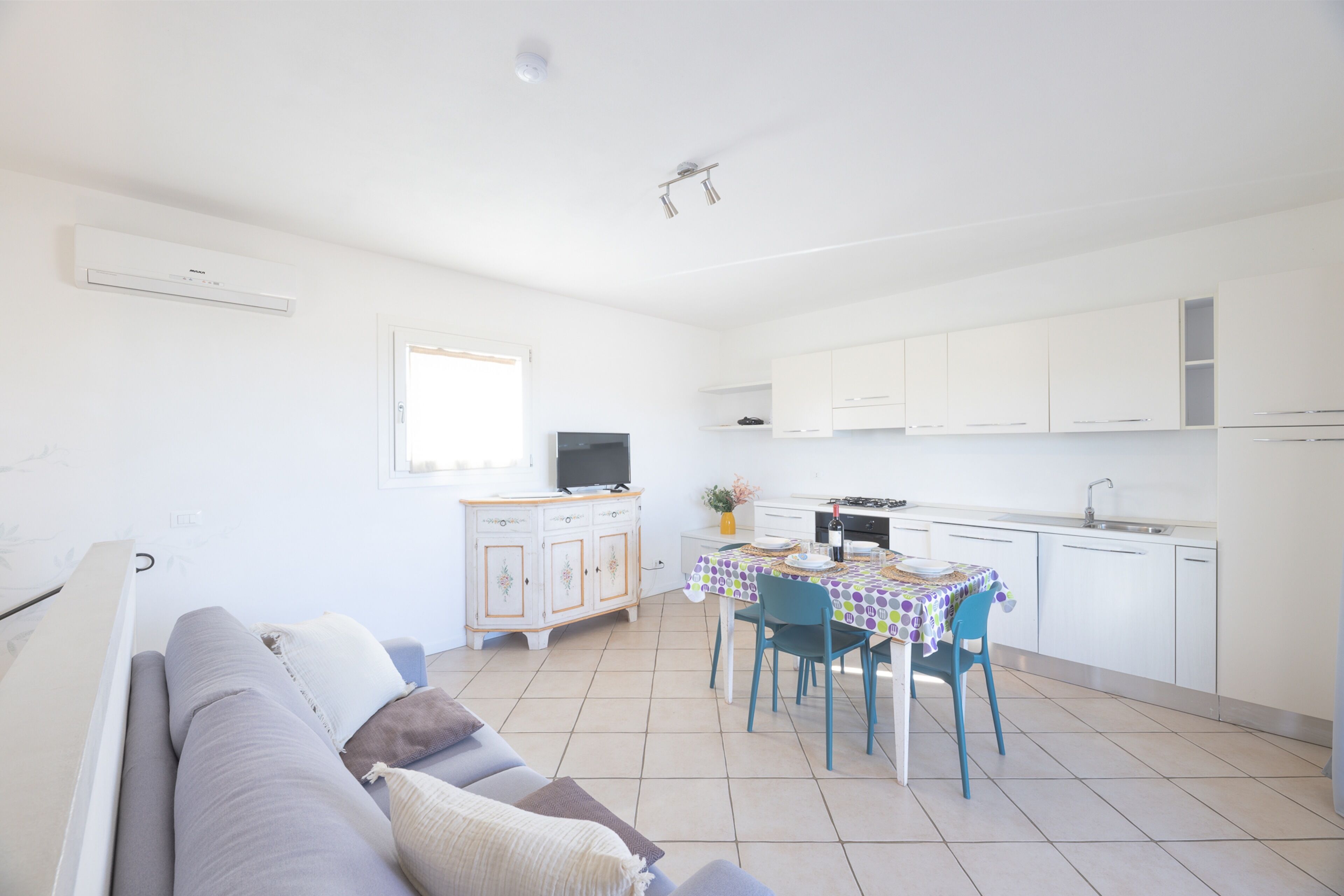 A modern apartment with a living room, dining area, and kitchen.