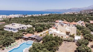 A residential area with modern houses, a swimming pool, and a view of the sea. - Apartment for 3 pax | Bellino Apartments (Chersonissos)