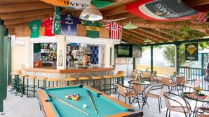 A pool table with billiard balls, a bar area with stools, and a seating area with tables and chairs. - Apartment for 3 pax | Bellino Apartments (Chersonissos)
