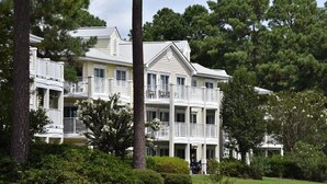 A multi-story hotel with balconies, surrounded by trees and greenery. - Studio Villa 509L at Brunswick Resort and Golf with Outdoor Pool and Beaches Nearby by RedAwning (Calabash)