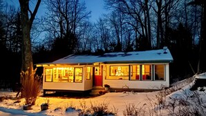 A modern house with a flat roof, large windows, and a snow-covered driveway. - Adirondack Retreat - Hot Tub & Lake (Keeseville)