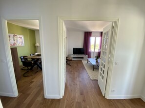 A living room with a TV, a dining table, and a sofa.