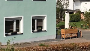 Un edificio con varias ventanas, una banca y un jardín.