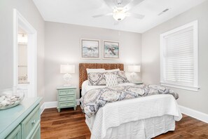 A bedroom with a bed, nightstands, a ceiling fan, and artwork on the wall. - Litchfield Home w/ Private Pool for Large Groups (Litchfield by the Sea)