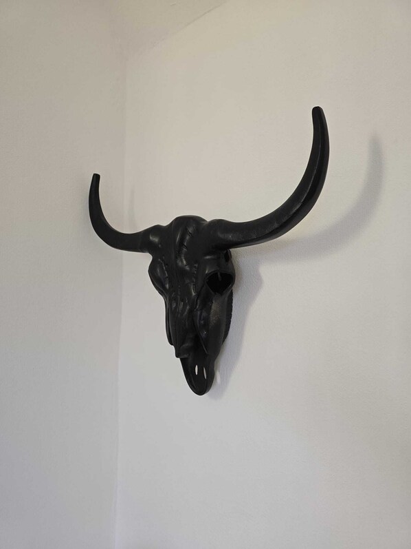 A black bull skull mounted on a white wall.