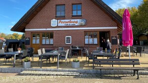 Um edifício de tijolos tradicional com uma placa que diz 'Peenchhaus Cafe & mehr'.