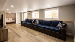 Une chambre d’hôtel moderne, dotée d’un grand canapé, d’un lit et d’une télévision.