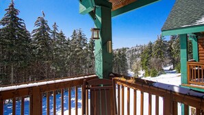 A wooden deck with a view of snow-covered trees and a clear blue sky. - Camp Four 23: Pet Friendly,  Slope side, Gas Fireplace. (Snowshoe)
