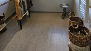 Un bagno con un'ampia finestra, una panca di legno con asciugamani, uno sgabello e cesti in vimini.