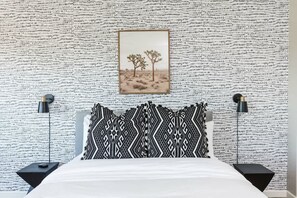 A bedroom with a patterned wall, a bed with black and white bedding, two bedside lamps, and a framed picture of trees. - Sereno- North Scottsdale- Private Pool & Games! (Scottsdale)