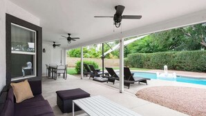 A covered outdoor area with a pool, lounge chairs, a sofa, and a table. - Sereno- North Scottsdale- Private Pool & Games! (Scottsdale)