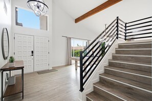 A modern interior with a wooden staircase, a dining area, and a view of the outdoors. - Sereno- North Scottsdale- Private Pool & Games! (Scottsdale)